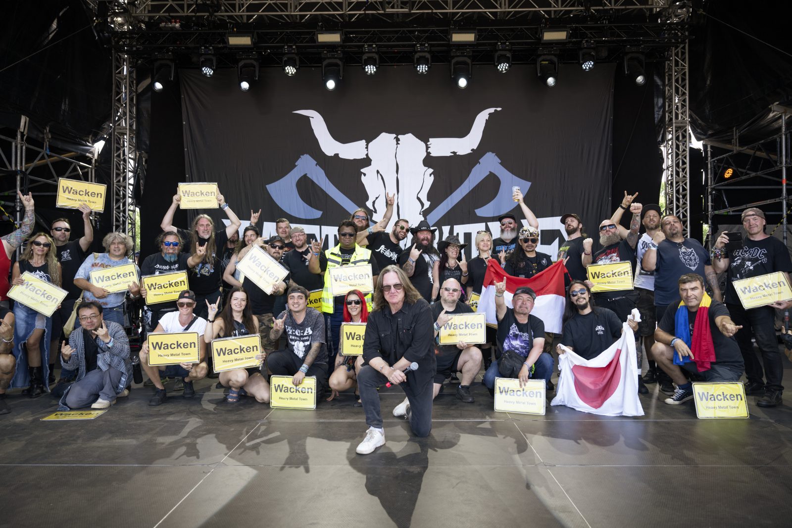 Metal Battle finalists on the Wacken stage with Heavy Metal Town signs